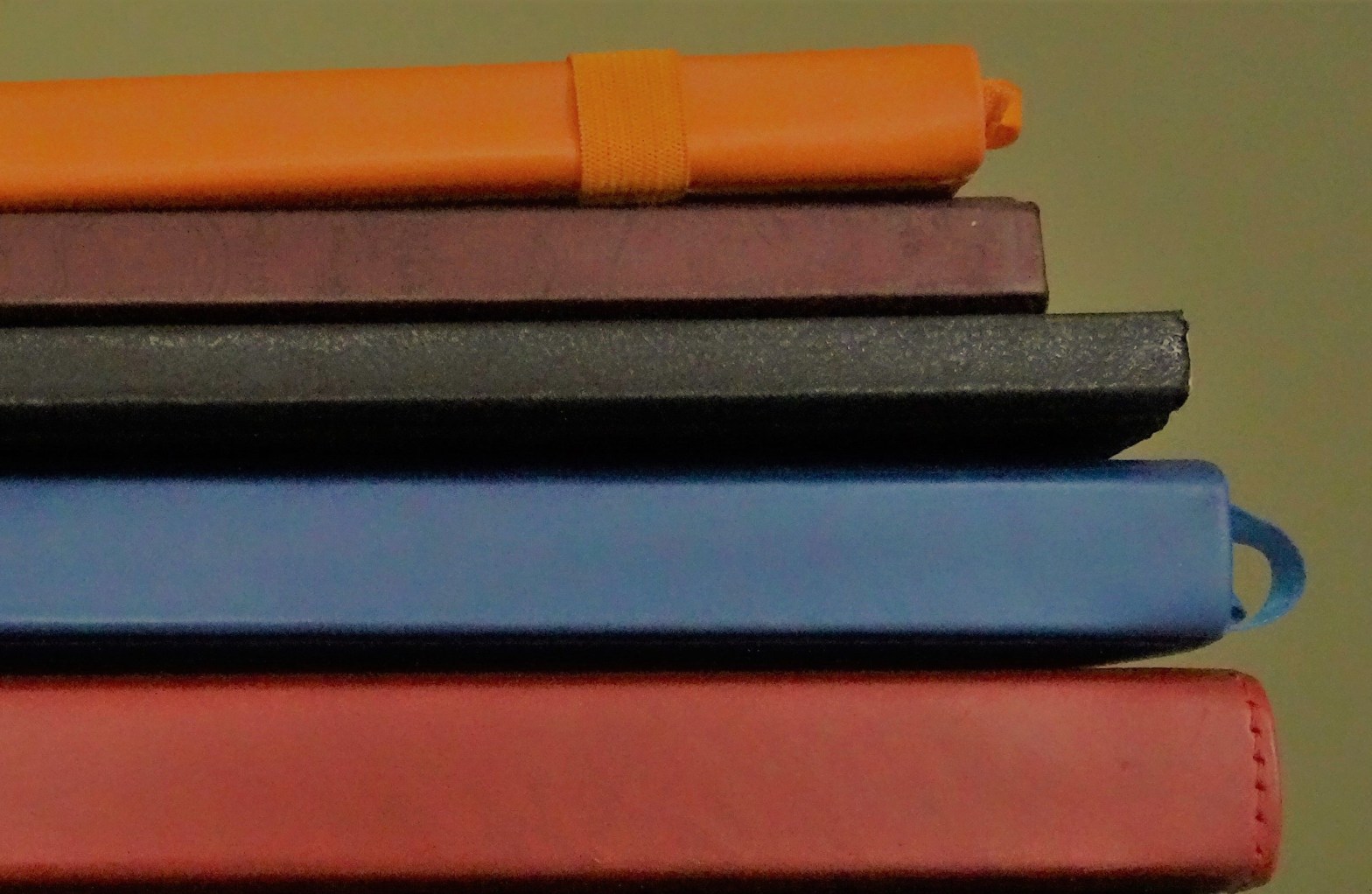 Close-up of multicoloured notebooks arranged like steps.